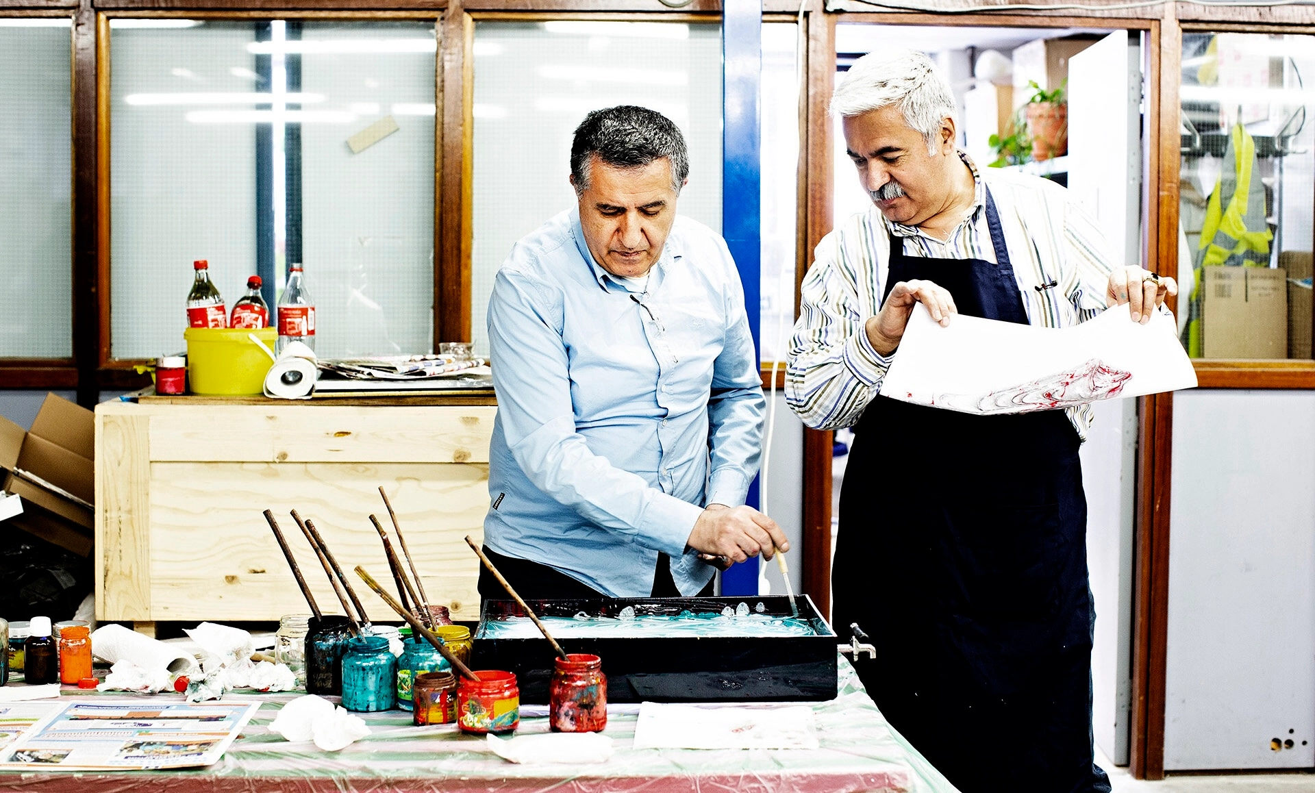 Two men painting in a studio.
