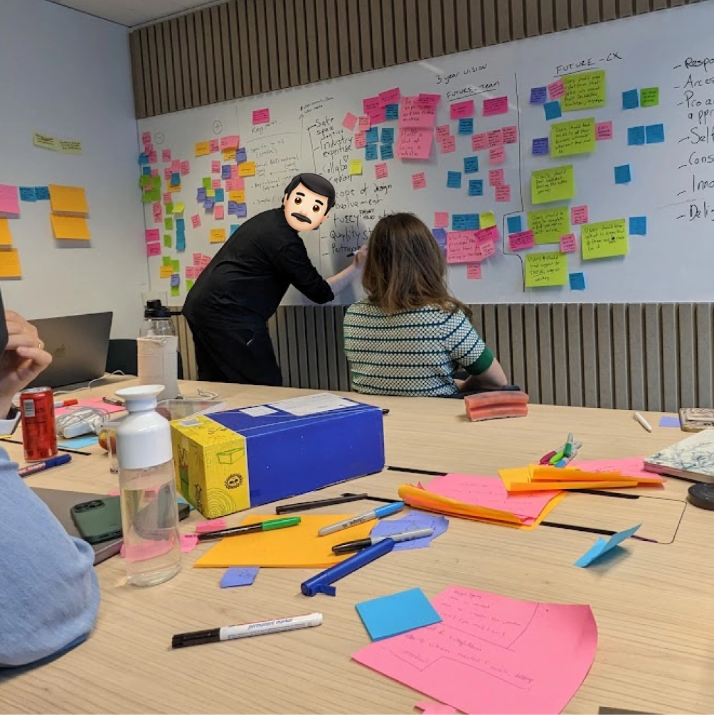 A group of people are brainstorming by writing and pasting post-its on a
whiteboard.
