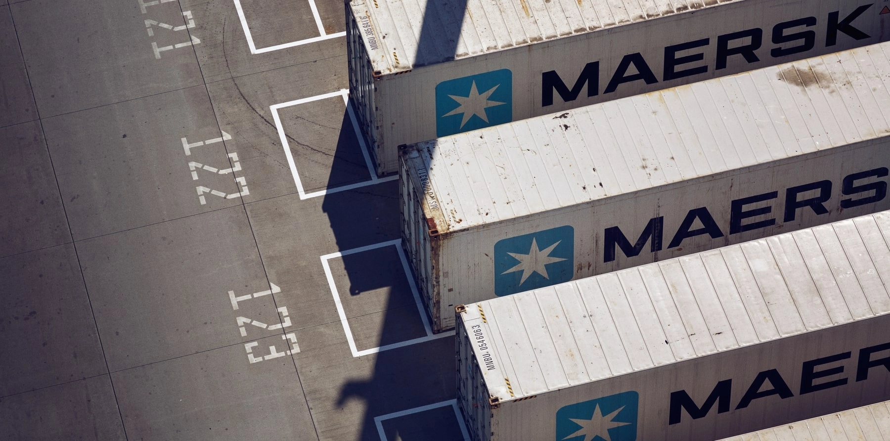 Perspective photo of Maersk containers arranged side-by-side at a port.